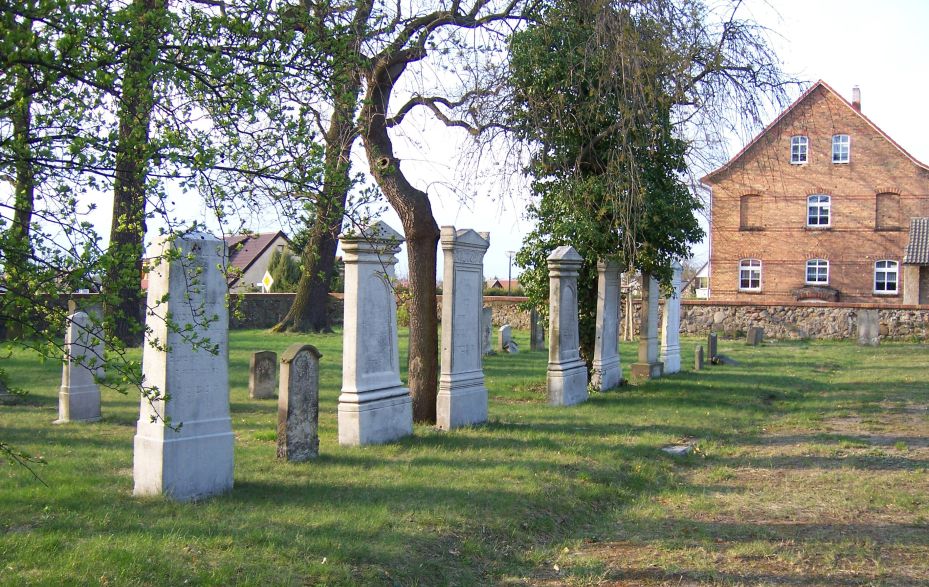 Grabsteine und Haus auf dem Friedhof
