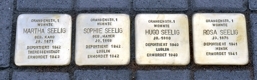 vier Steine mit Namen im Straßenpflaster
