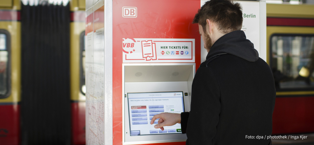 Junger Mann am Fahrkartenautomat