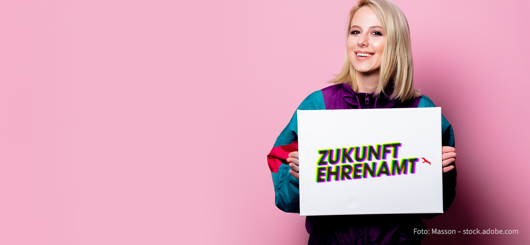 Eine junge Frau präsentiert das Logo des Ideenwettbewerbs 