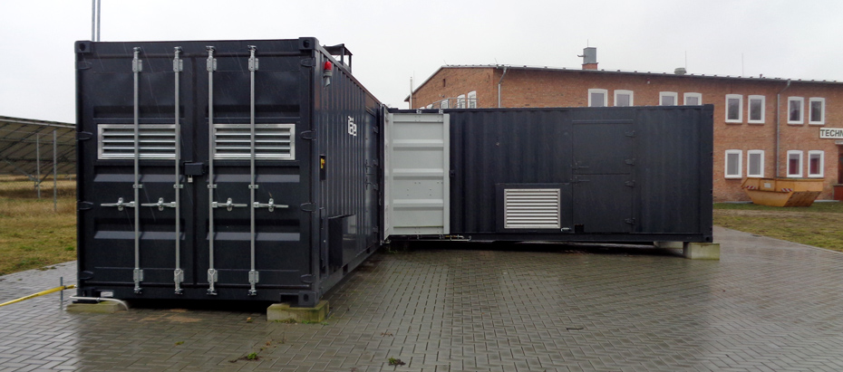 Foto: dunkelblaue Container vor Backsteingebäude