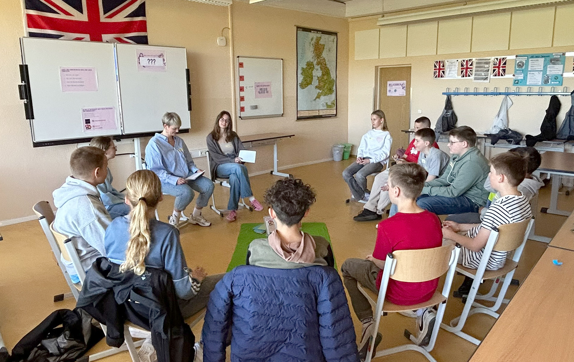 Foto: Gruppe sitzt im Kreis in einem Klassenraum Foto: Gruppe sitzt im Kreis in einem Klassenraum