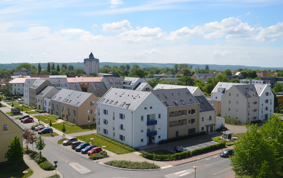 Foto: Regenbogensiedlung, im Hintergrund ein Hochhaus