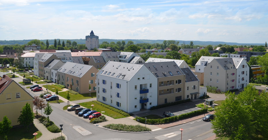 Foto: Regenbogensiedlung, im Hintergrund ein Hochhaus