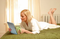 Foto: Leserin mit Tablet auf dem Bett liegend Foto: Leserin mit Tablet auf dem Bett liegend