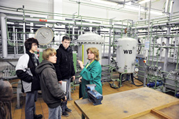 Foto: 3 Jugendliche informieren sich am Arbeitsplatz einer Facharbeiterin. Foto: 3 Jugendliche informieren sich am Arbeitsplatz einer Facharbeiterin.