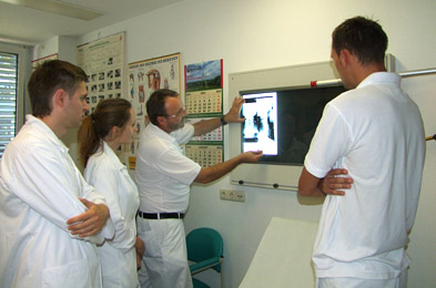 Foto: Arzt und Studenten mit einer Röntgenaufnahme Foto: Arzt und Studenten mit einer Röntgenaufnahme
