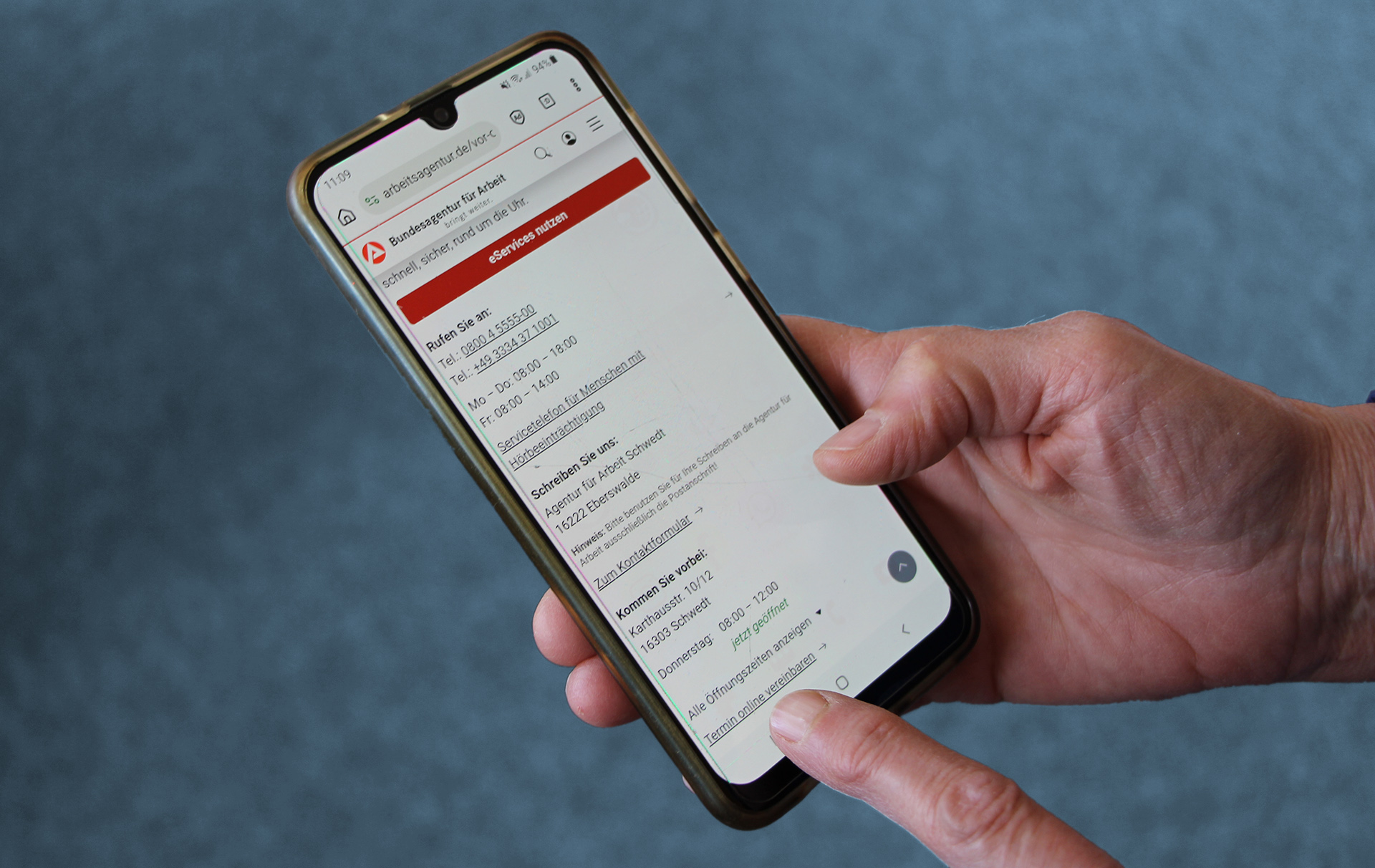 Foto: Hand mit Handy mit Fingerzeig auf den Link Foto: Hand mit Handy mit Fingerzeig auf den Link