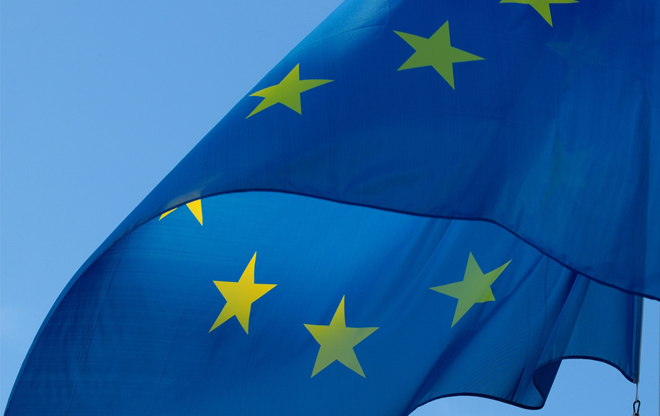 Foto: blaue EU-Fahne vor blauem Himmel