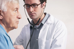 Foto: Arzt horcht einen Patienten ab. Foto: Arzt horcht einen Patienten ab.