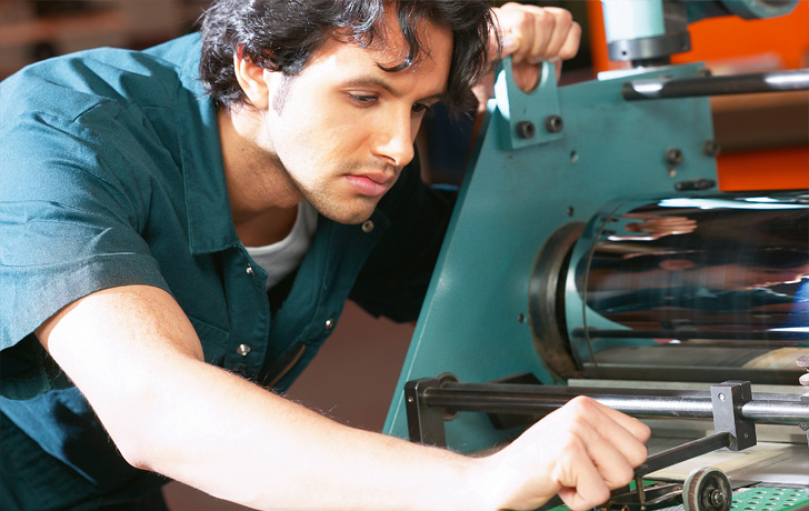 Foto: Arbeiter an einer Maschine Foto: Arbeiter an einer Maschine