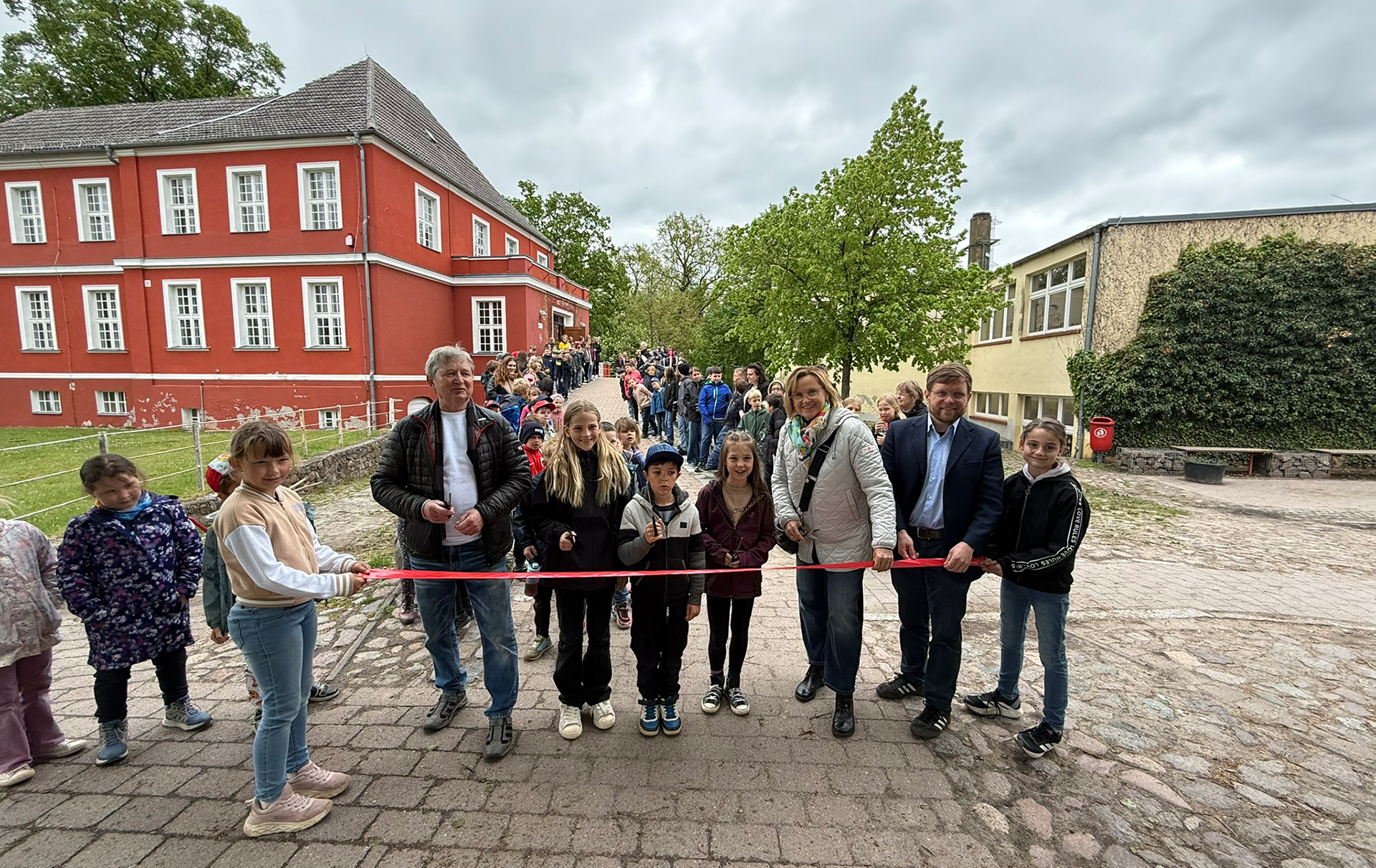 Foto: Banddurchschnitt mit Offiziellen und Schülern Foto: Banddurchschnitt mit Offiziellen und Schülern