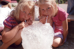 Foto: 2 Mädchen baim Blasen in einen Schaumberg