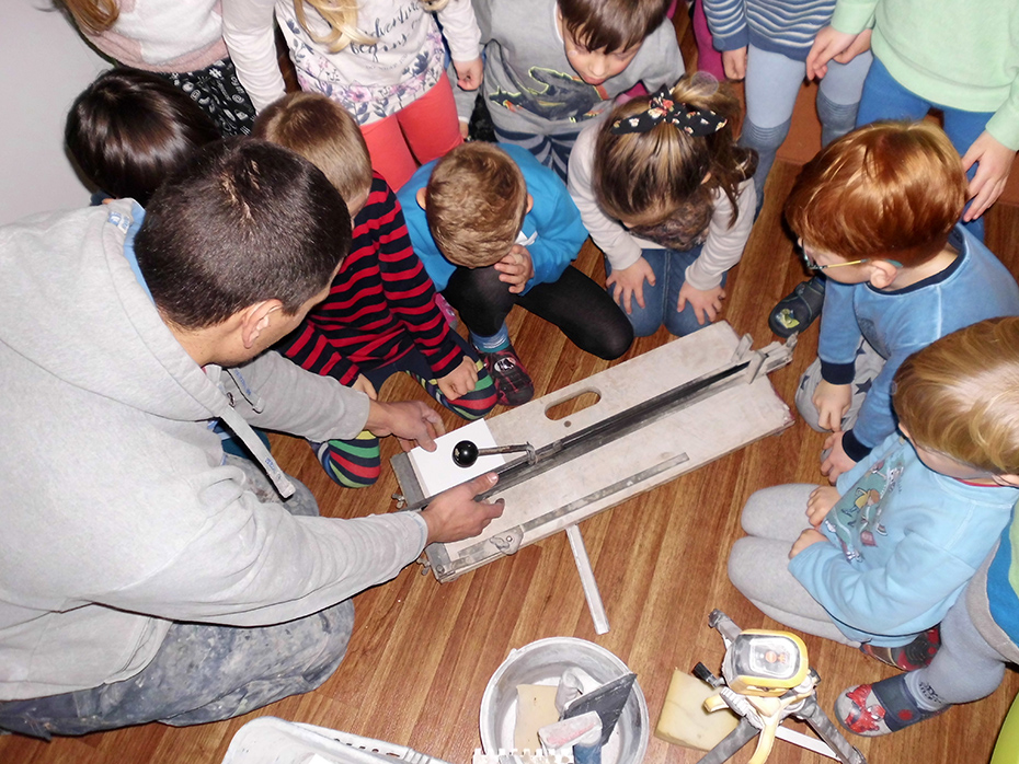 Foto: Kinder schauen einem Handwerker zu