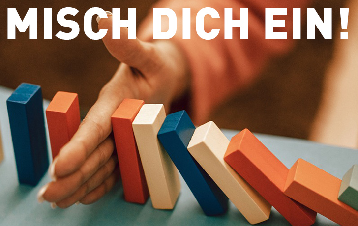 Foto: Motto auf einem Foto, das eine Hand zwischen Dominosteinen zeigt Foto: Motto auf einem Foto, das eine Hand zwischen Dominosteinen zeigt