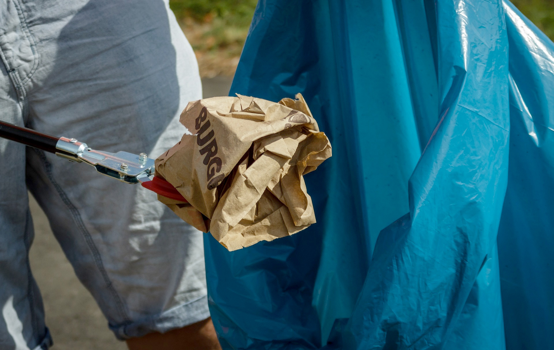 Foto: Müll mit der Zange erfasst und auf dem Weg in den Müllbeutel Foto: Müll mit der Zange erfasst und auf dem Weg in den Müllbeutel