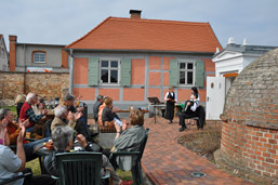 Foto: Garten mit Besuchern vor dem Synagogendienerhaus Foto: Garten mit Besuchern vor dem Synagogendienerhaus