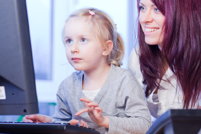Foto: Mutter schaut ihrer am Computer sitzenden Tochter über die Schulter Foto: Mutter schaut ihrer am Computer sitzenden Tochter über die Schulter