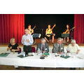 Foto: Präsidium und 3 Musikerinnen auf der Bühne