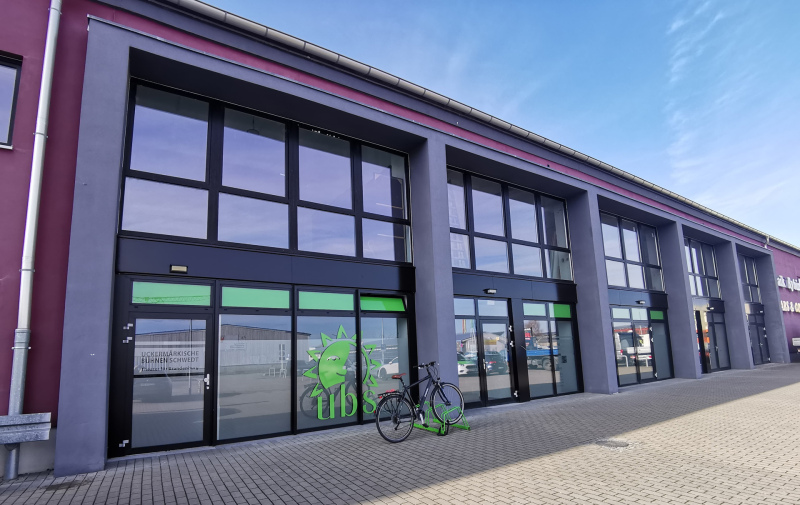 Foto: Haus mit Glasfassade und grünem Fahrradständer mit einem Fahrrad davor Foto: Haus mit Glasfassade und grünem Fahrradständer mit einem Fahrrad davor