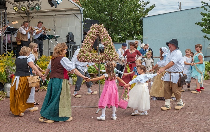 Viele Menschen in traditioneller Kleidung tanzen um die Tabakkrone Viele Menschen in traditioneller Kleidung tanzen um die Tabakkrone