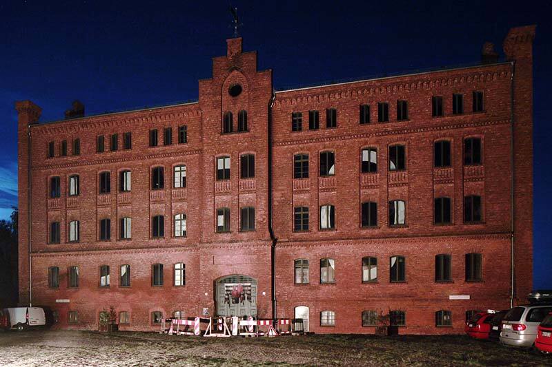 Foto: Tabakfabrik nachts mit beleuchtetem, abgesperrtem Eingang Foto: Tabakfabrik nachts mit beleuchtetem, abgesperrtem Eingang