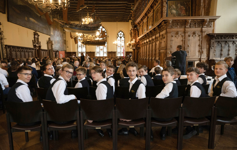 Foto: festlich gekleidete Knaben in einem Saal drehen sich nach hinten um und blicken in die Kamera Foto: festlich gekleidete Knaben in einem Saal drehen sich nach hinten um und blicken in die Kamera