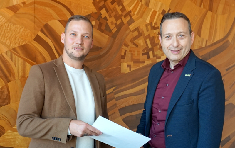 Foto: eine Person übergibt einer anderen ein Schreiben Foto: eine Person übergibt einer anderen ein Schreiben