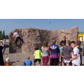 Foto: Kinder und Kletterer vor einem Kletterfelsen