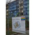 Foto: Bauzaun mit Informationstafel vor einem Abrissblock