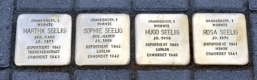 vier Steine mit Namen im Straßenpflaster vier Steine mit Namen im Straßenpflaster