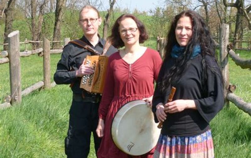 Zwei Frauen und ein Mann halten Instrumenten in der Hand. Sie stehen auf einer Wiese. Zwei Frauen und ein Mann halten Instrumenten in der Hand. Sie stehen auf einer Wiese.
