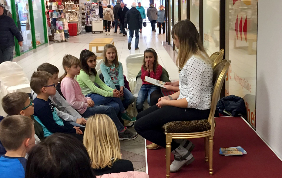Foto: Kindergruppe sitzt vor einer Vorleserin in den Passagen Foto: Kindergruppe sitzt vor einer Vorleserin in den Passagen