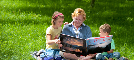 Frau liest Kindern aus einem Buch vor